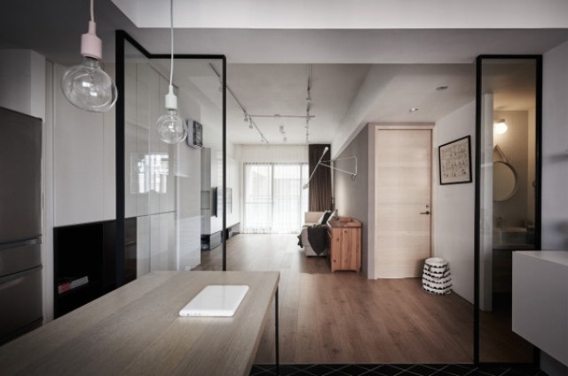 Glass doors used throughout the apartment divide the spaces but help the rooms look bigger