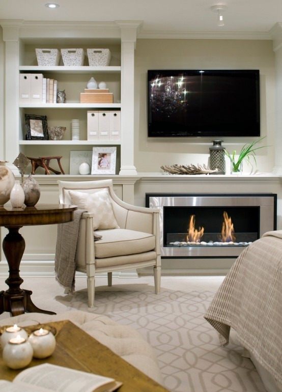 an elegant neutral living room with built-in bookshelves, a built-in fireplace, a TV and elegant furniture plus a dark-stained round table