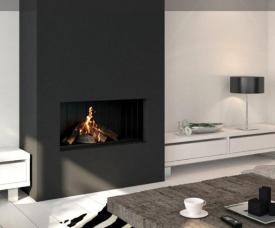 a minimalist black and white living room with a large built-in fireplace, white walls and white sleek furniture, a low coffee table and a printed rug