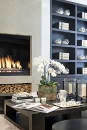 a chic modern living room with a built-in fireplace and built-in bookshelves, a low coffee table, a built-in firewood storage niche