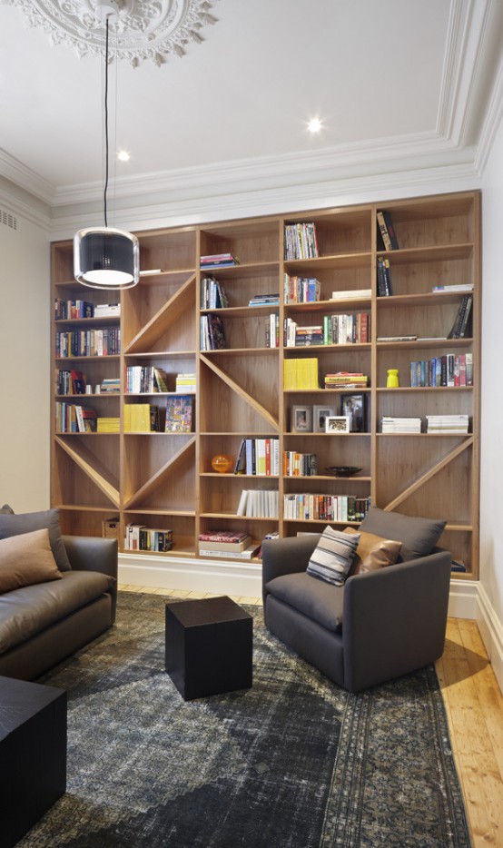 a modern home library with a large shelving unit and grey furniture plus some lights