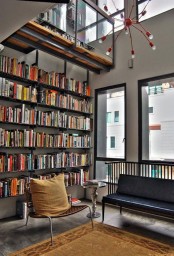 a modern sleek library with lots of floating shelves and some comfy sitting furniture plus a red chandelier