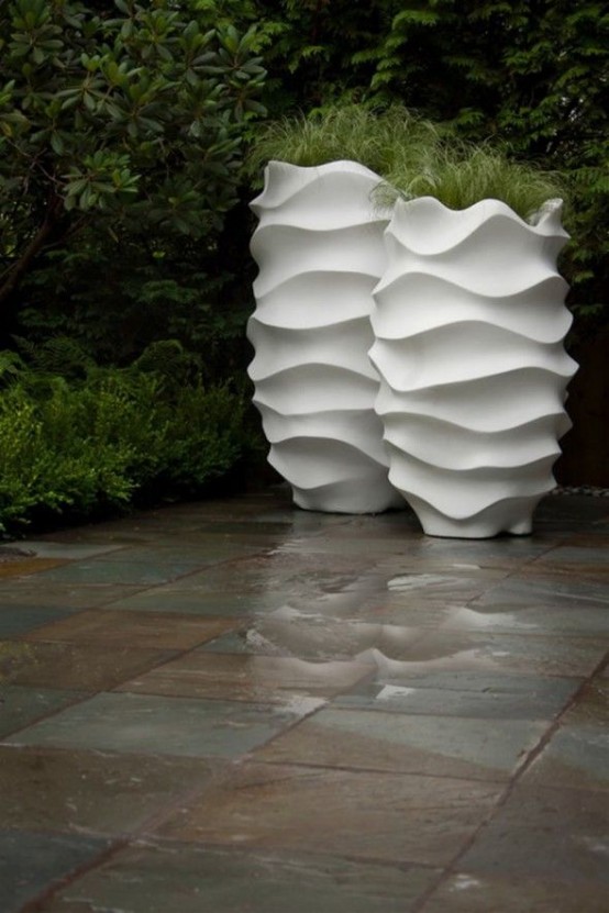 a modern tall white surrealistic planters with greenery will give a modern and atful feel to your backyard