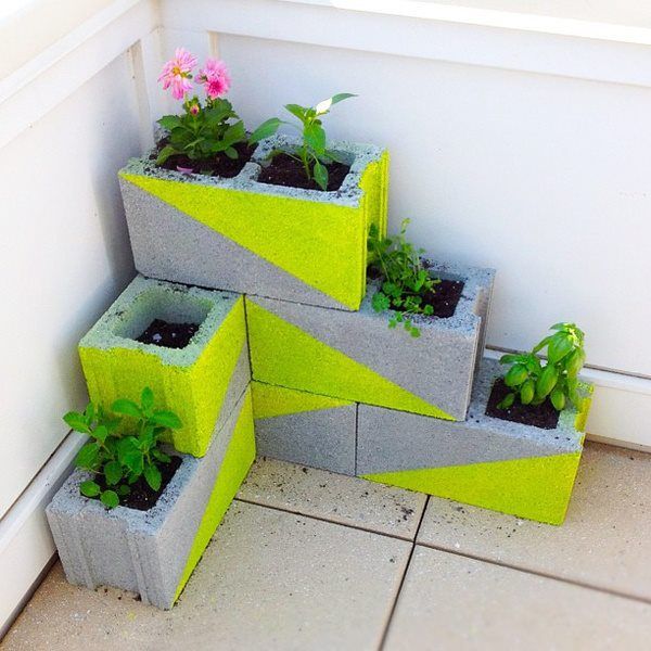 stacked concrete planters with geometric neon touches and blooms and greenery will give a minimalist feel to your space