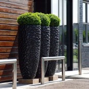 ultra-modern tall black planters with a bubble pattern are chic and bold decorations to rock for outdoors