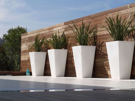 tall white planters placed in a row will highlight your outdoor space giving it a modern feel and a chic look