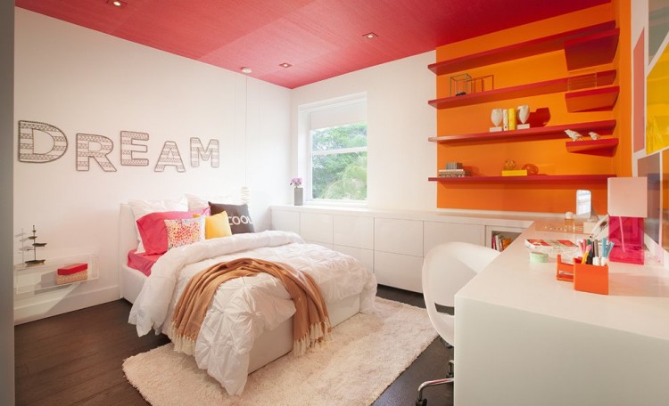 a white teen girl bedroom with a red ceiling and an orange and red accent wall, with sleek minimalist furniture