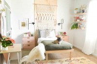 a neutral boho teen bedroom with blush and stained wooden furniture, a macrame hanging, printed bedding and rugs