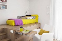 a modern teen bedroom with a bed on a platform that contains drawers and a desk plus a white curved chair