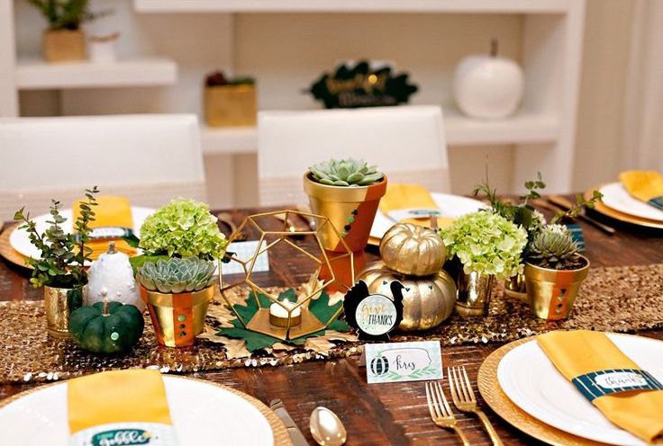a modern colorful Thanksgiving tablescape with a glitter runner, gold, green and white pumpkins, potted greenery and colorful napkins
