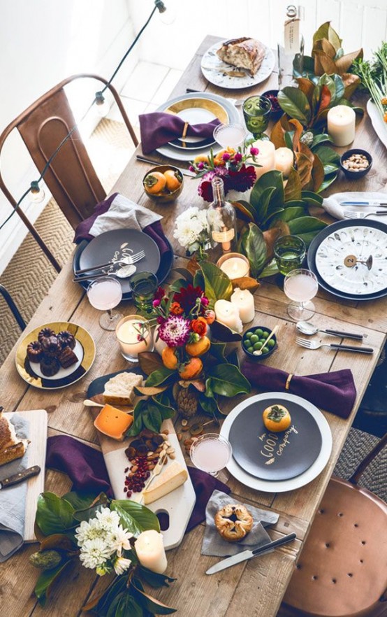 a modern super bold Thanksgiving tablescape with foliage, bold leaves, deep purple napkins and white and black plates