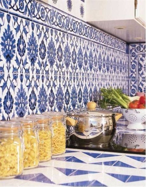 a white modern kitchen with a blue Moroccan tile backsplash and a blue geo tile countertop is a catchy and practical space to rock
