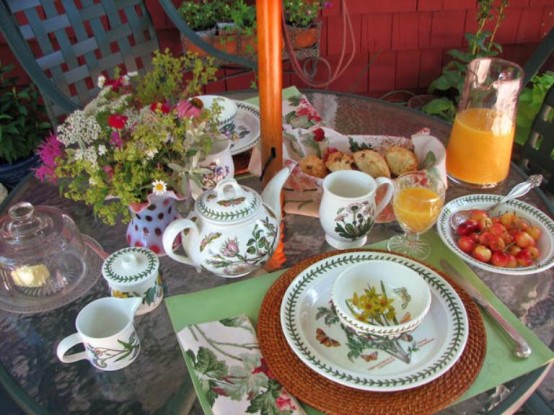 a simple wedding table setting with bright blooms and berries, a green placemat and a woven charger, floral porcelain