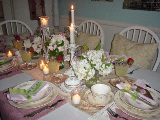 a vintage neutral and pastel-colored tablescape with with a floral runner, pink placemats, floral porcelain, neutral blooms and candles, pastel napkins