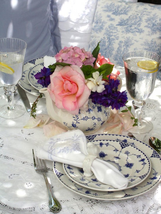 elegant vintage-inspired wedding tablescape with a lace tablecloth. bright blooms, blue printed porcelain and gold-rimmed glasses