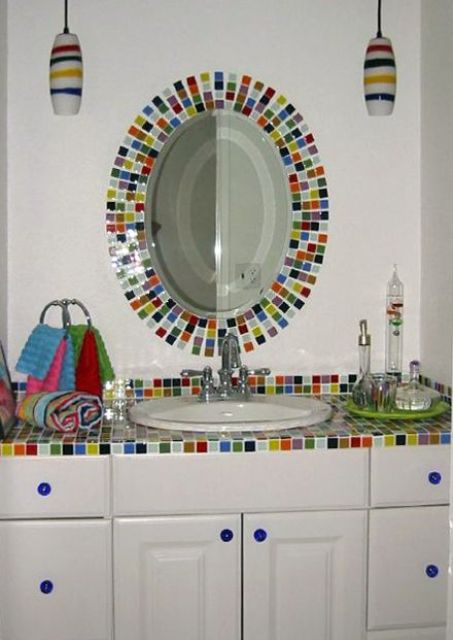 a white bathroom accented with super bright and colorful tiles on the vanity and mirror frame is a great idea for a kid's bathroom
