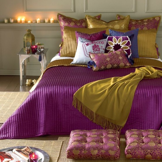 a neutral Moroccan bedroom done with jute, carved tables and lamps and super bright fuchsia and mustard bedding