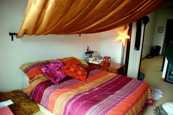 a Moroccan bedroom done with extra bright textiles and a canopy, lanterns and a star-shaped lamp