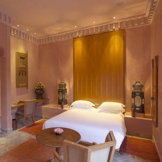 a blush and mustard Moroccan bedroom with large lanterns, ornate shutters, wood and metal furniture