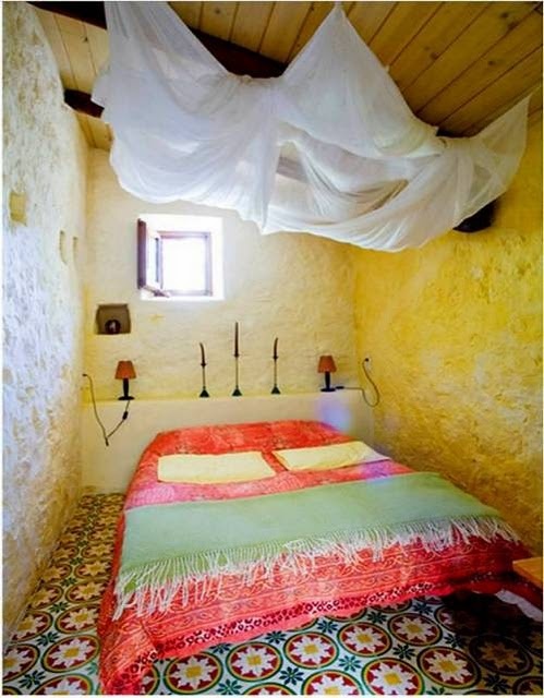 a Moroccan tile floor, bright bedding and candle holders add a strong Moroccan feel to the space