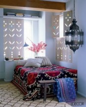 carved wooden shutters, a Moroccan lantern and bright printed textiles create a bold Moroccan look