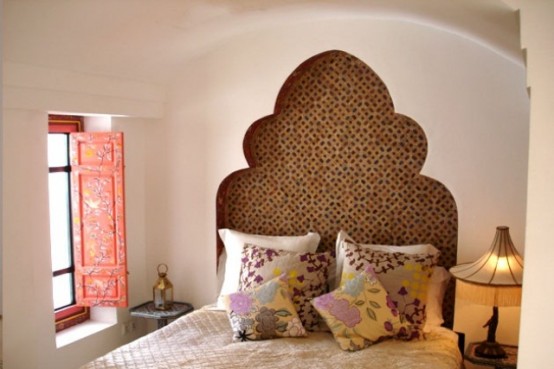 a red ornate shutter and a carved out headboard to add an Eastern feel to the bedroom