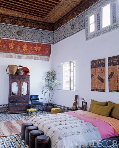 the floor clad with Moroccan tiles, colorful panels on the ceiling and walls, carved furniture and bright textiles