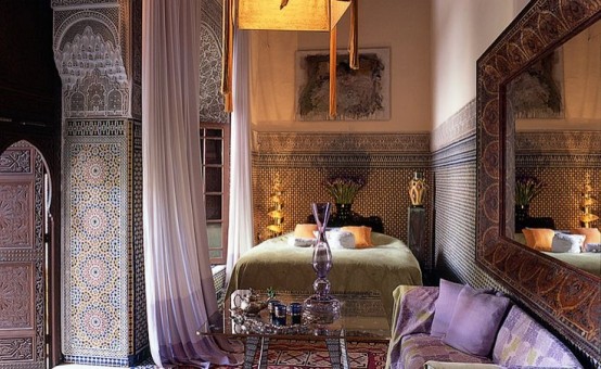 a chic Moroccan bedroom with lavender accents, mosaic tiles and pillars plus carved wooden shutters