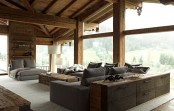 a welcoming chalet living room with plenty of natural light, grey seating furniture and a wooden coffee table, chic floor lamps and a console table with storage