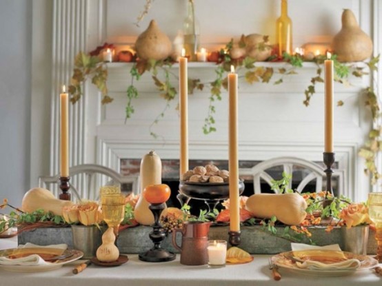 a warm-colored tablescape with bright squashes, bold candles, leaves and some matching blooms is chic and cozy