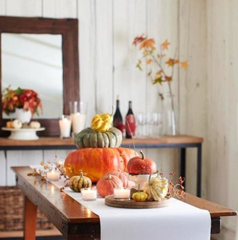 bold heirloom pumpkins and berries placed on a white table runner are amazing for a natural and chic Thanksgiving table
