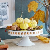 a stand with neutral pumpkins, nuts and acorns will work as a nice decoration or centerpiece for Thanksgiving