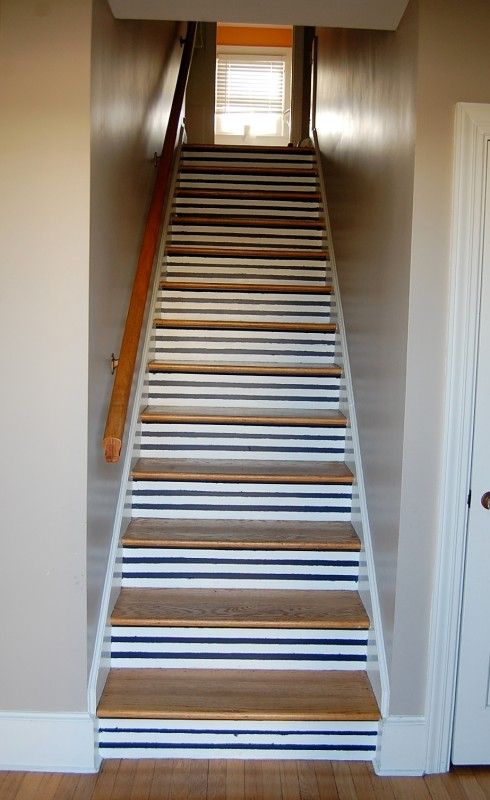 a cool staircase with traditional nautical striped backing is a pretty idea for a nautical space