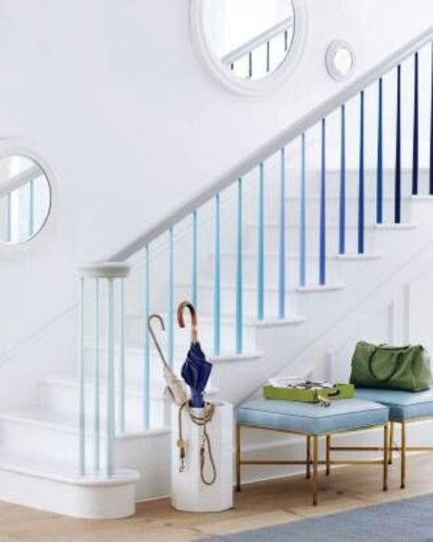 a nautical staircase with ombre railing from light blue to deep navy tones is a very bold idea, and round mirrors add a sea feel here