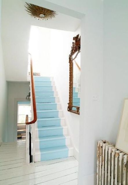 a coastal staircase with light blue steps and stained railing is a lovely idea for a coastal or beach space