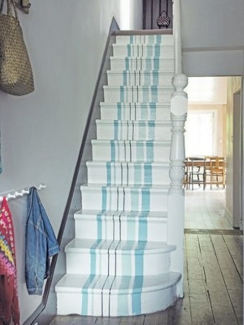 a nautical staircase with vertical stripes in mint blue and light blue going along the whole staircase