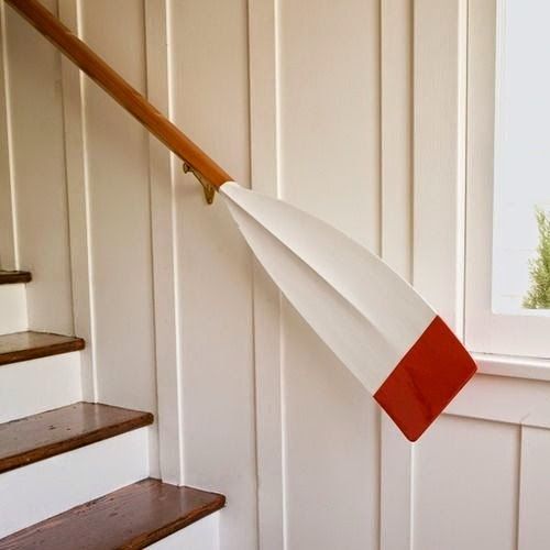 a simple white staircase turns into a nautical one thanks to an oar rail looks cool and bold