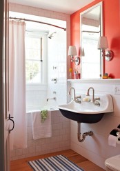a bright orange wall in the sink zone accents it and make the neutral vintage bathroom brighter and whimsier