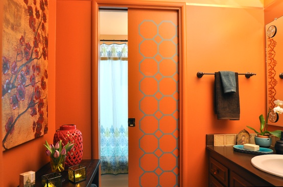 an orange bathroom with Eastern motifs and artworks is a very cheerful idea that will remind of summer every time