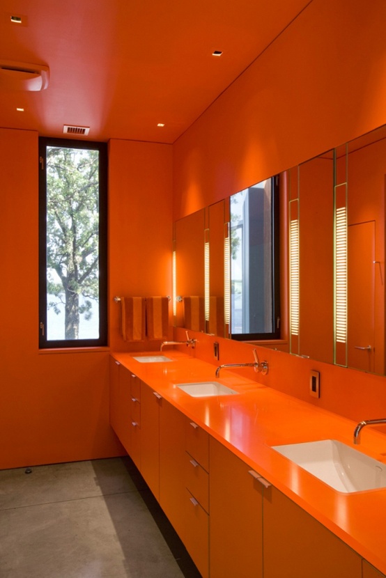 an all-orange bathroom calmed down with a simple concrete floor will flood you with color and brightness