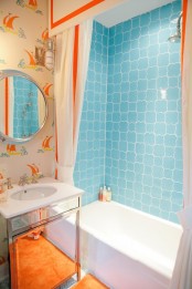 white, blue and orange compose a timeless combo and bright sailboat prints create a gorgeous kids’ bathroom with a fun touch