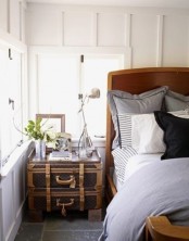 a chic and stylish wedding nightstand of a stack of vintage suitcases and a mirror top, some greenery and table lamps is amazing