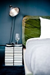 a creative wedding nightstand composed of only stacks of books, a sconce and glasses is a very sophisticated idea