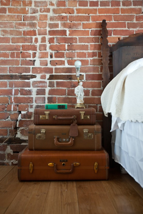 a vintage nightstand of a stack of vintage suitcases, with books and statuettes is a lovely idea for a vintage bedroom