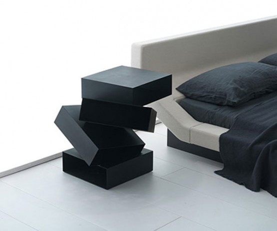 a unique black nightstand that seems to be composed of black boxes chaotically placed on each other is a very beautiful idea