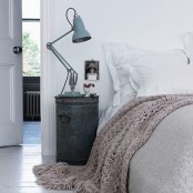 a dark metal nightstand with a blue metal table lamp is a chic idea for a Scandinavian bedroom and it will give a rustic feel to the space