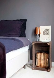 an old crate piece with an artwork and a table lamp is a small and easy nightstand to rock, it will bring a rustic feel to the space