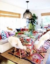 a super bright boho dining room with a flower pendant lamp, wicker shades, bright boho textiles