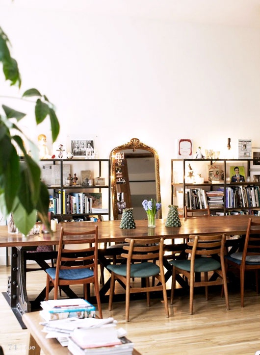 a stylish mid-century modern dining room with a wooden dining set, open shelving and a mirror in a chic frame