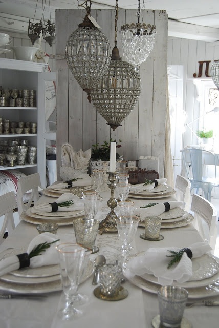 a shabby boho dining space with large glass pendant lamps, whitewashed shiplap walls and vintage furniture
